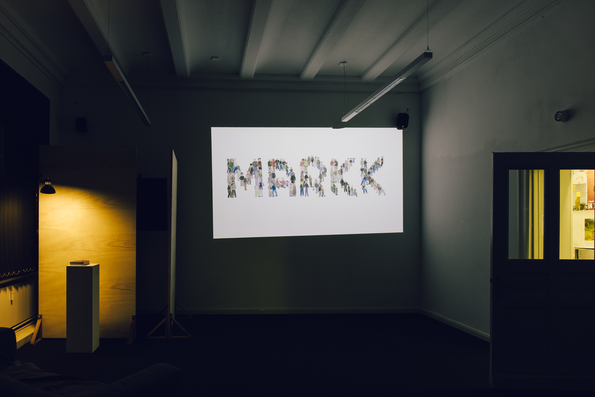 Markk Illustration an der Wand in einem dunklen Ausstellungsraum