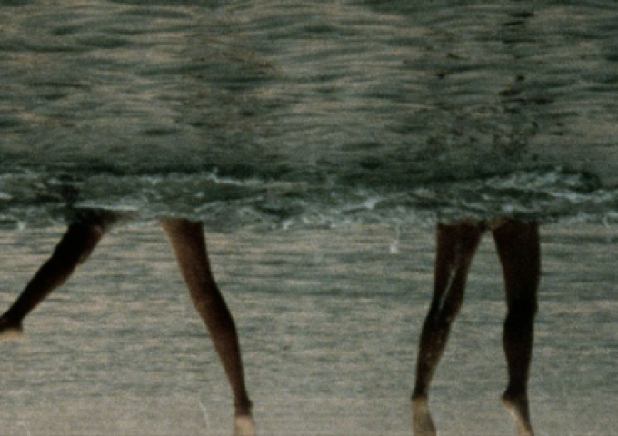 Fotografie zweier Beinpaare, die aus dem Wasser ragen (Bild auf den Kopf gestellt)