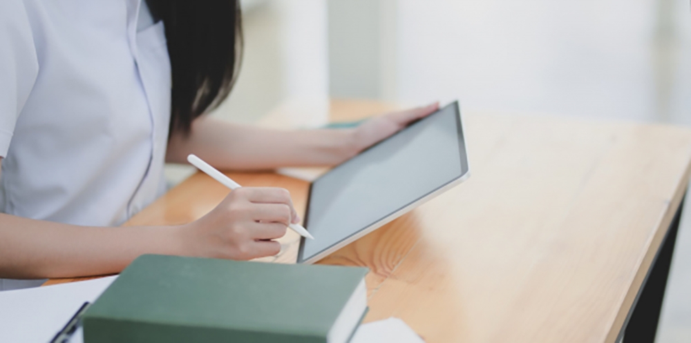 Frauenarme mit einem Stift und Tablet