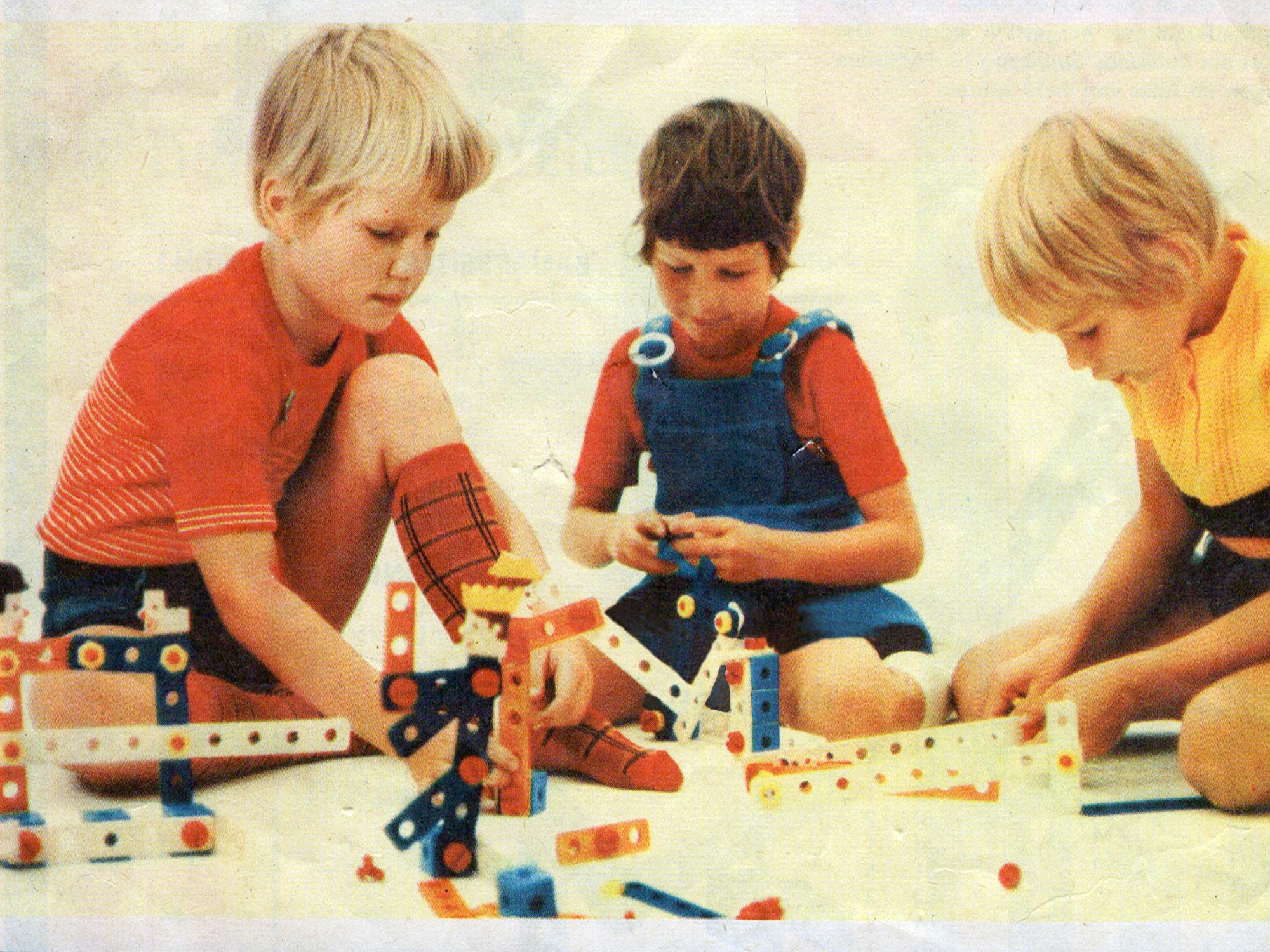 Drei Kinder spielen mit Baukasten